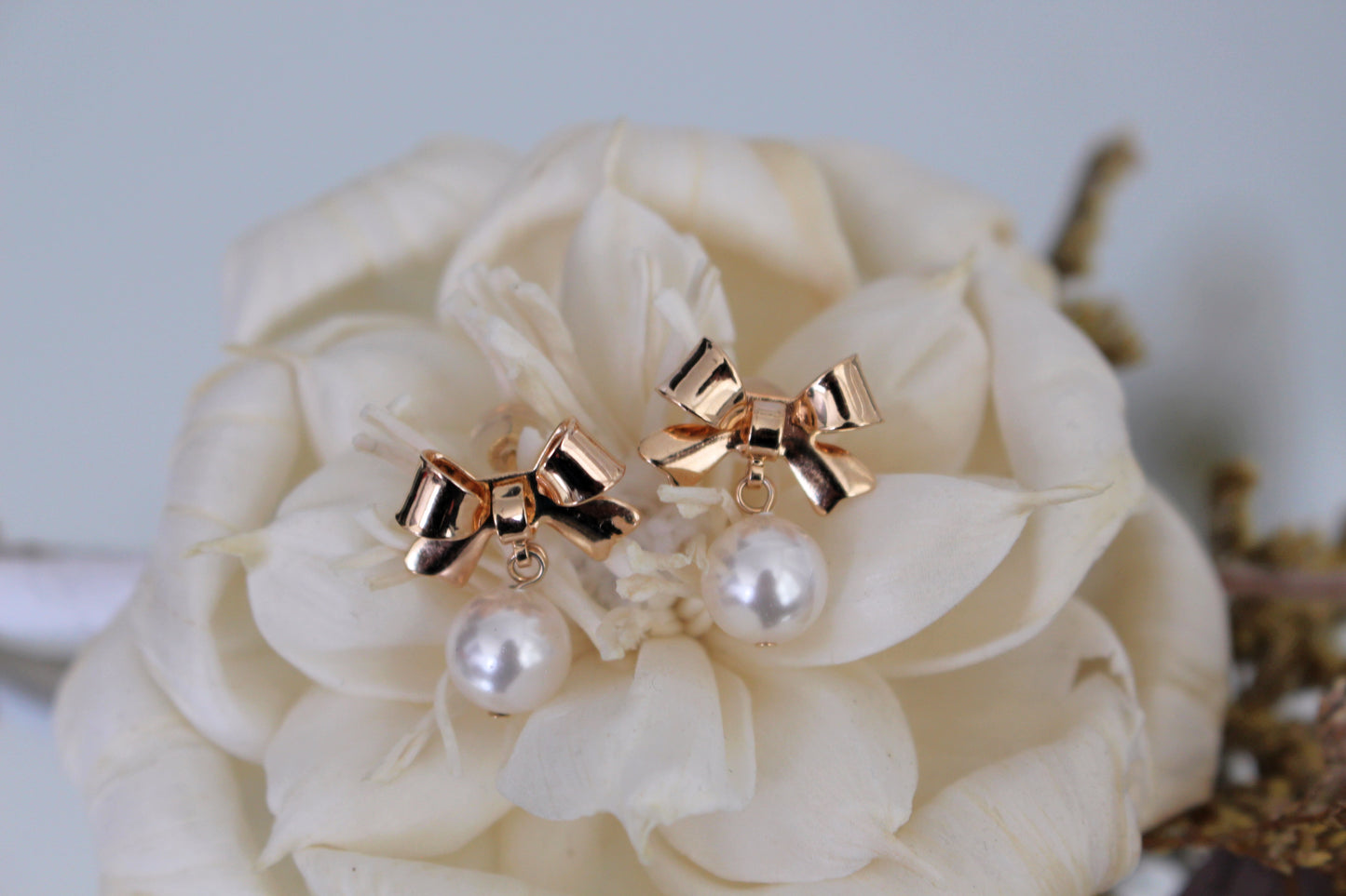 Lovely gold bow earrings on rose display
