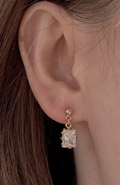 model wearing gold antique earrings on ears