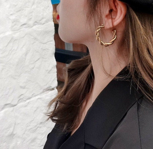 model wearing medium size twisted gold hoops minimalist earrings